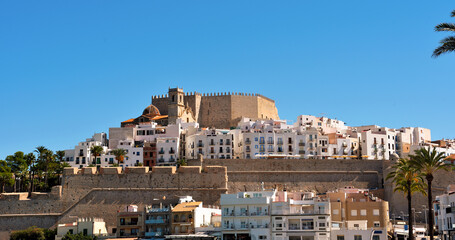 view of Peñíscola, a coastal city in Spain, located in the region of Valencia. The city is known for its castle, built on a rocky peninsula that juts out into the sea