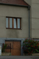 A wellconstructed concrete building exhibiting a stylish window and a charming wooden door,...