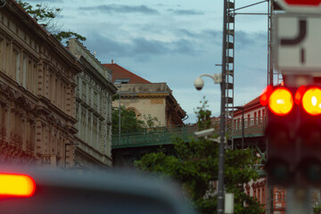 A captivating street view showcasing stunning historical architecture, visible traffic lights, and a beautifully cloudy sky, all set against the backdrop of an urban environment