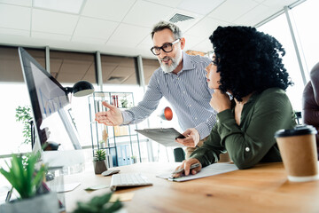 Focused professionals in a modern office setting collaborating on a project, demonstrating teamwork dynamics and workplace productivity