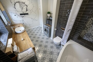modern bathroom with black and white patterned tiles, a large floral mural, a wooden vanity, a...