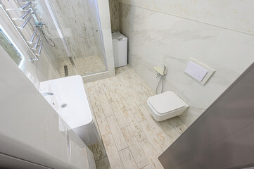 bright, modern bathroom features white fixtures, tiled walls and floor. The space includes a...