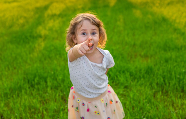 Child pointing forward in nature. Selective focus.