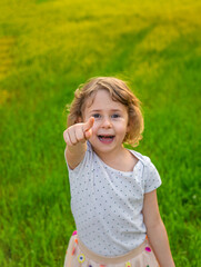 Child pointing forward in nature. Selective focus.
