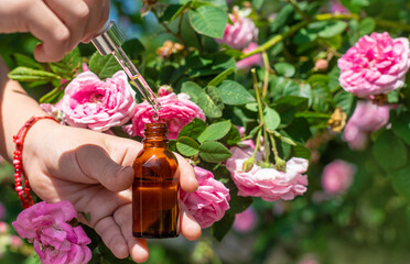 Rose essential oil in a bottle. Selective focus.