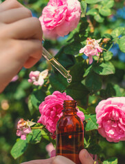 Rose essential oil in a bottle. Selective focus.