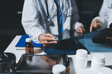Male and female doctors are having a meeting in a hospital room.