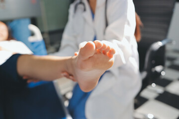 Female doctor hands doing physical therapy By extending the leg and knee of a male patient