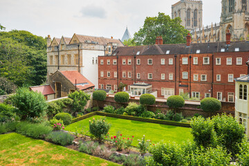 Picturesque city apartments and lush lawns seen within the famous English city of York. York cathedral can be seen towering in the background.