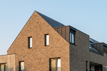 Modern brown single-family house photographed from the outside, with clear architectural lines and...