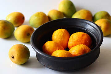 Peeled ripe mangoes in an earthen pot, ready for cooking in a Kerala style curry with yogurt, coconut, and spice