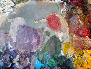 Close-up of an artist’s palette filled with mixed oil paints. Textured colors background. Horiszontal
