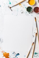 Blank canvas surrounded by paint splatters and brushes