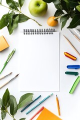 Fresh, vibrant art supplies arranged around a blank notebook