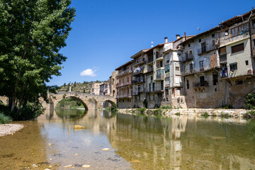 Fototapeta premium Stone bridge over the Matarraña River with a scenic view of Valderrobres Castle and Santa María la Mayor Church, in Teruel, Aragón, Spain.