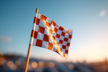 Checkered race flag waving proudly on a wooden pole during sunset at a motorsport event