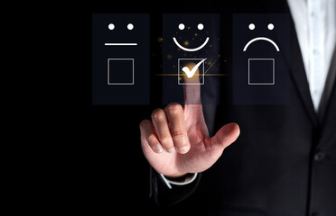 Finger of businessman touching and check mark icon face emoticon smile on dark background, service mind, service rating. Satisfaction and customer service concept 