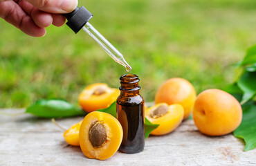 Apricot essential oil in a bottle. Selective focus.