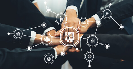 A group of diverse professionals joining hands in a modern office, symbolizing collaboration and teamwork, enhanced by digital icons representing productivity and success. Amity