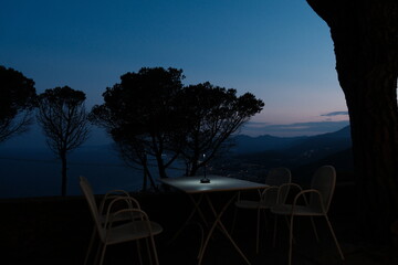 restaurant table lit up at night with a splendid sea view on the Ligurian coast of the western Riviera