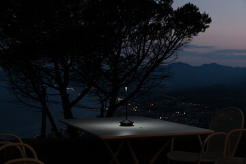restaurant table lit up at night with a splendid sea view on the Ligurian coast of the western Riviera