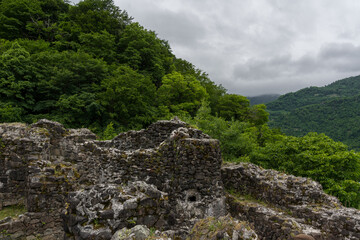 The ruined wall of the fortress of Gvara, Georgia, mountains, clouds