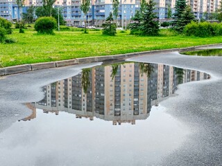 Reflection of the building in the puddle on the street.