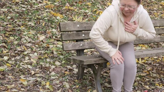 Middle aged woman holding chest in pain, sudden cardiac symptom, heart discomfort, possible rare cardiac condition, health risk