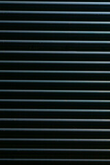 Obraz premium In the image, you can see a series of evenly spaced horizontal stripes set against a deep black background, which can be used effectively for various design and texture applications