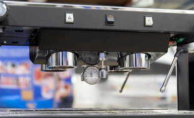 Chrome group head and pressure gauge on professional espresso machine