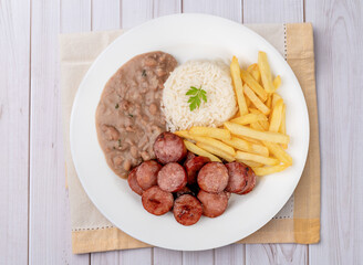 Sausage, rice, beans and french fries. Typical brazilian executive dish