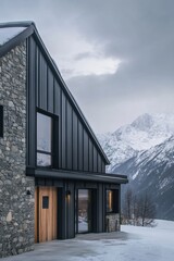 Fototapeta premium A contemporary mountain house, crafted from stone and metal, is beautifully situated amidst a snowy landscape, surrounded by majestic peaks beneath a gray, overcast sky