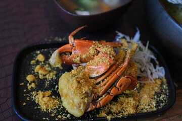 Crab legs served with herbs and vegetables in butter sauce on white plate. High quality 4k footage