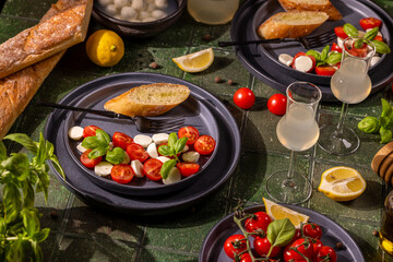 Fresh caprese salad with lemon and baguette