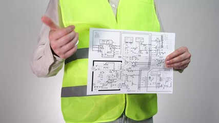 Builder engineer with a light bulb in his hands and a diagram. Electrical installation diagram in the hands of an electrical engineer.