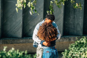 romantic couple of young latinos embracing on the street