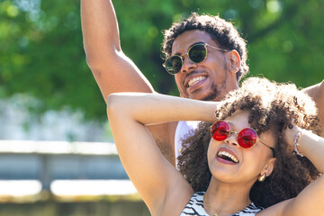 young latin couple smiling happily, laughing