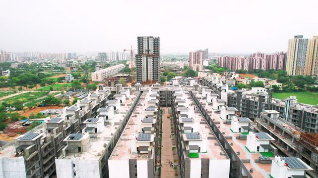 aerial drone shot flying low forward over similar houses with solar panels on roof showing affordable housing in Gurgaon, Delhi, Mumbai, Ahmedabad India