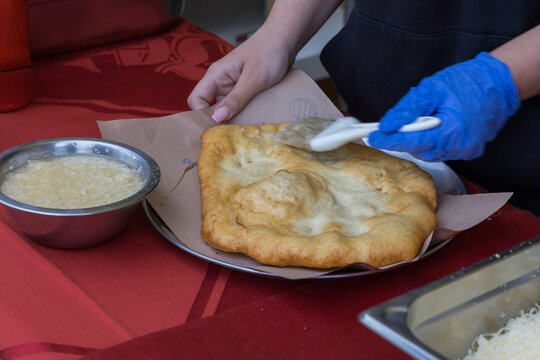 Langos dough delicacy topped with cheese and rubbed with garlic