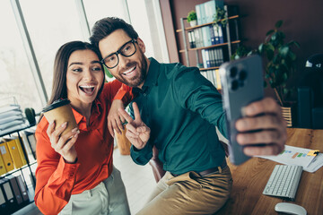 Young colleagues in a stylish office take a cheerful photo while enjoying teamwork and collaboration moments while working.