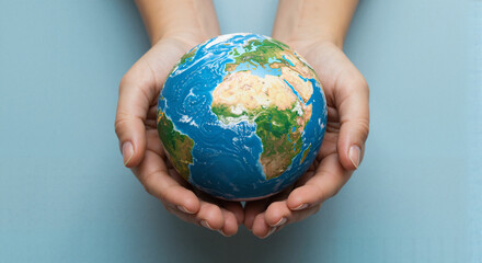 Hands holding a globe on a blue background representing Earth
