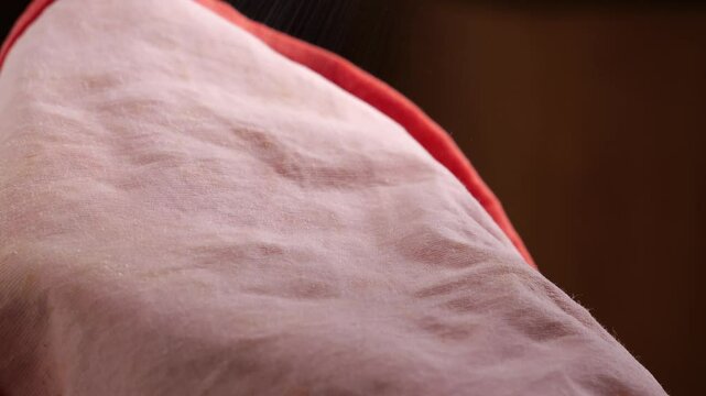 The stain removal spray is sprayed on the pink fabric.