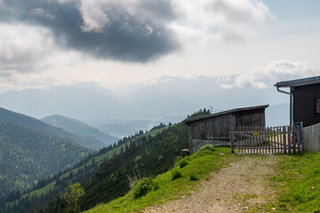 Hiking above the clouds on Wankberg, Germany—panoramic views of snow-capped Alps and lush valleys under a bright blue sky.