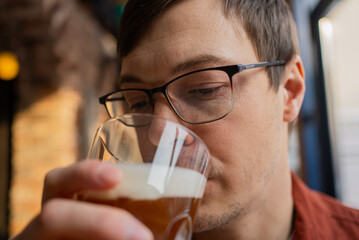 Brewer enjoying the aroma of craft beer in a glass at a brewery or bar, savoring a fresh recipe while engaging in quality control for the perfect brew experience