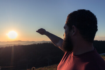 Fototapeta premium man at sunset in the mountains looking deeply thoughtfully at the horizon