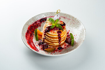 Pancakes with jam and mint on a white table