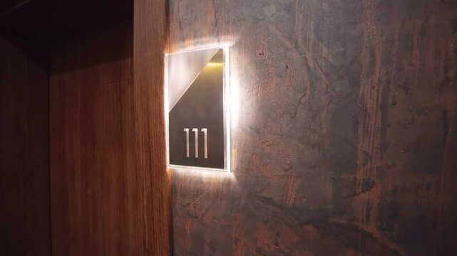 Modern dark-themed hotel corridor with illuminated room number 111