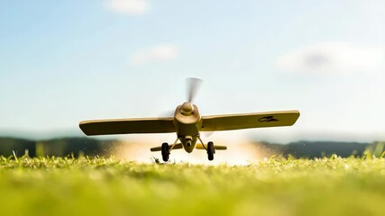Aircraft modeling. A small plane is flying over a field of grass. The plane is white and has a yellow stripe