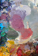 Close-up of an artist’s palette filled with mixed oil paints. Textured colors background. Vertical