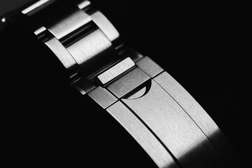 Elegant closeup of a metal watch bracelet buckle in monochrome view